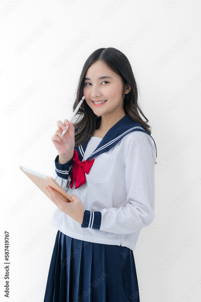 happy cheerful asian girl in japanese student uniform with tablet for online study on white background happy cheerful asian girl in japanese student uniform with tablet for online study on white background