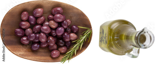 Brown olives in plate by oil in jar