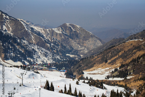 Almaty Kazakhstan 25 March 2023. Medeo Shymbulak Mountain Resort's ski slopee with skiers and snowboarders. Skiers at slopes of ski resort Chimbulak.  photo