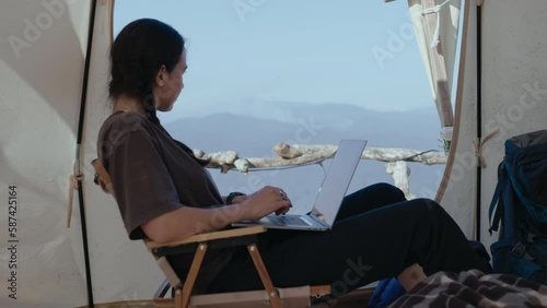 Wallpaper Mural Girl sitting in camping tent, working on laptop, looking at scenic view of mountains. Digital nomadism, getaway in nature concepts Torontodigital.ca