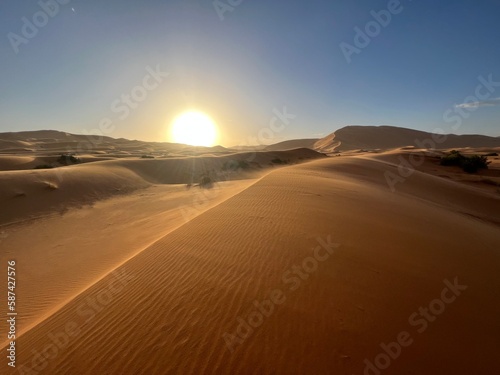 Dunes in the Sahara desert, Merzouga desert, grains of sand forming small waves on the dunes, panoramic view. Setting sun. Morocco 