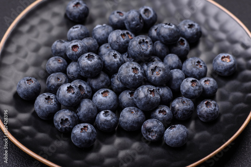 Delicious fresh blueberries on a textural black concrete background
