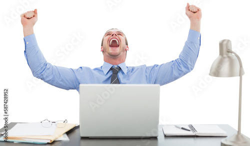 Successful businessman with hands raised sitting at desk