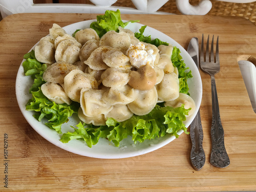 Dumplings with sour cream and mustard on a wooden background