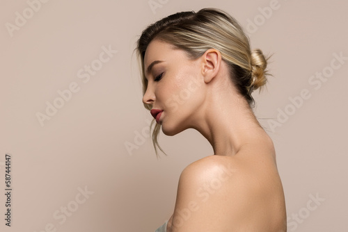 Obraz na plátně Young beautiful woman stands on her side with bare shoulders and back