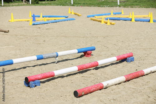 Horse obstacle course outdoors summertime. Poles in the sand at equestrian center outdoors