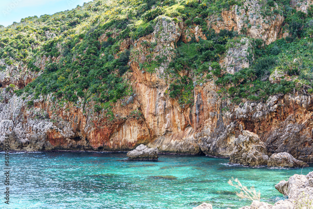 Beautiful views of the turquoise sea surrounded by huge rocky walls and mountain vegetation.