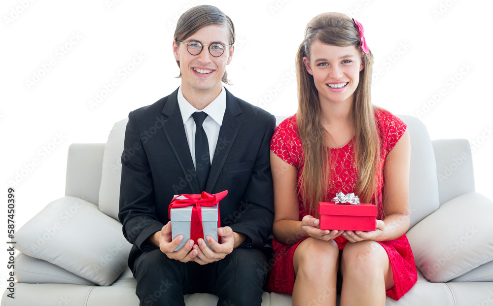 Cute geeky couple smiling and holding gift Cute geeky couple smiling and holding gift