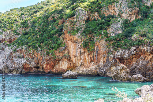 Beautiful views of the turquoise sea surrounded by huge rocky walls and mountain vegetation.