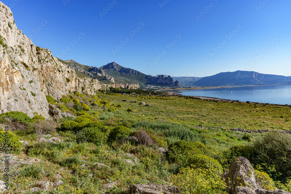 a beautiful view of the mountain peaks covered with dense vegetation and a view of the warm blue sea.
