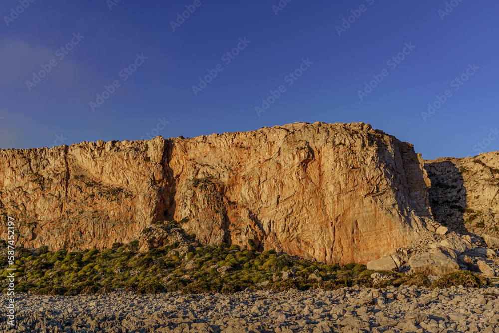 A huge climbing wall on one of the Sicilian peninsulas at sunset.