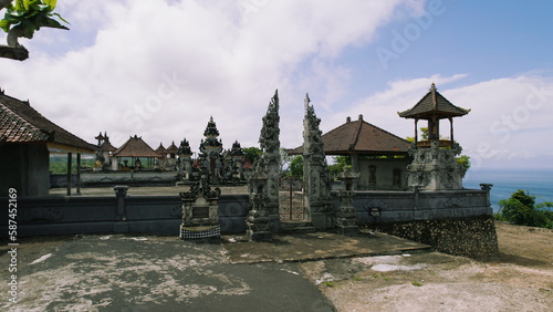 Traditional Temple Pura on Nusa Penida Island Bali Indonesia. Kelingking beach on tropical coastline with ancient building religion monument.