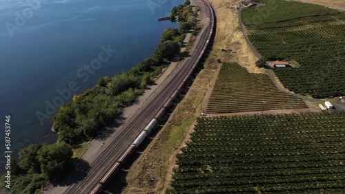 Pan up from a cargo train by the Columbia River