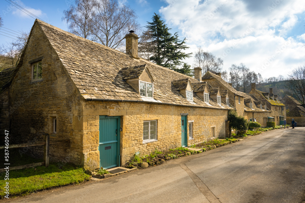 Medieval stone built traditional cottages with green door at Snowshill in Cotswolds, England