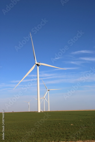Vertical image of giant wind turbines in a field