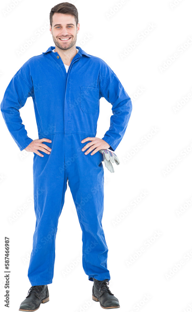 Smiling mechanic with hands on hips standing by tire Smiling mechanic with hands on hips standing by tire