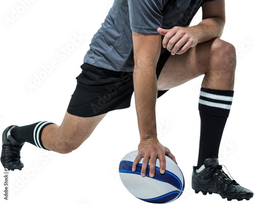 Rugby player in black jersey stretching with ball