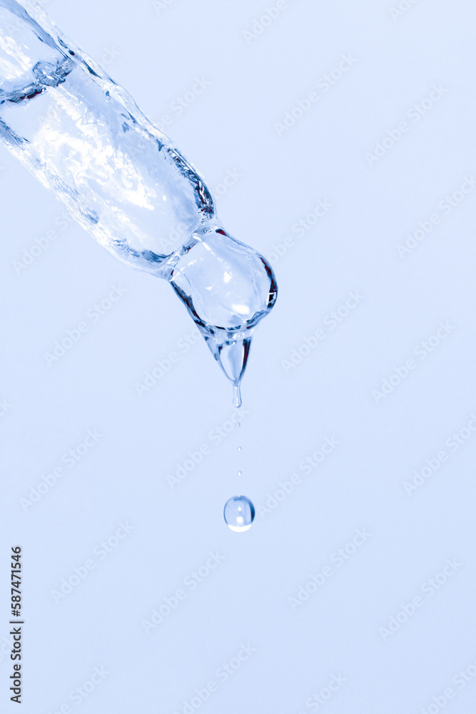 Cosmetic pipette with dripping liquid and drops on a blue background, serum, serum, gel, vitamin, water, oil. Clean, fresh, moisturizing Cosmetic pipette with dripping liquid and drops on a blue background, serum, serum, gel, vitamin, water, oil. Clean, fresh, moisturizing