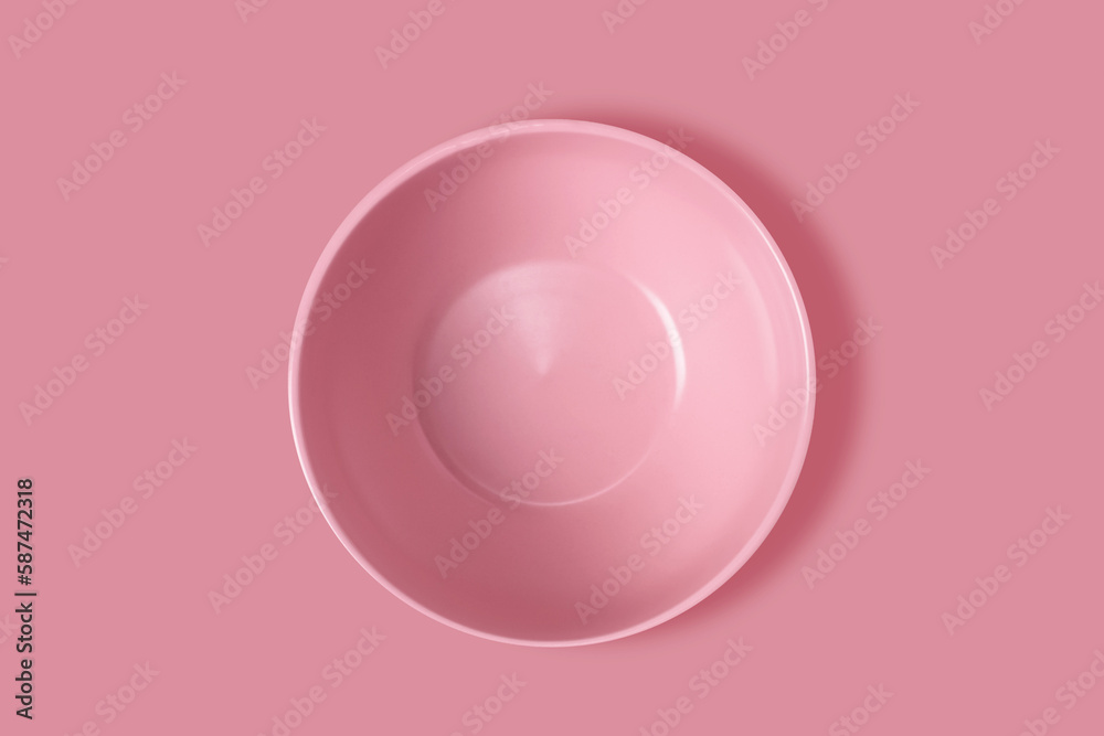 Pink plate on a pink background. View from above. Concept Pink plate on a pink background. View from above. Concept