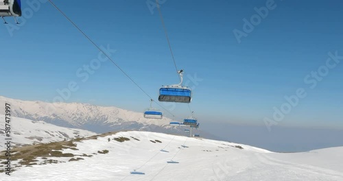 Riding ski chair lift on sunny winter day photo