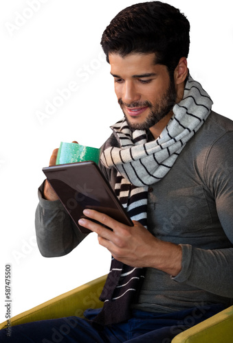 Man using digital tablet while having cup of tea