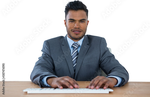 Portrait of businessman typing on keyboard at desk