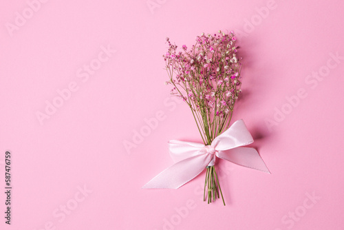 Delicate dry pink flowers. Small flowers. On a pink background. Spring  feminine  cute. Pink background. Flowers. Dried flowers. Empty space. Bouquet.
