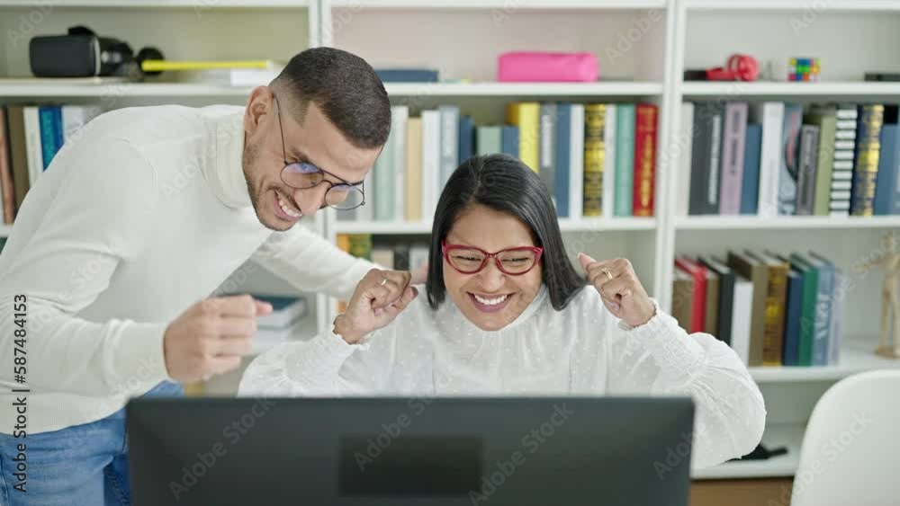 Man and woman students high five with hands raised up at university classroom Man and woman students high five with hands raised up at university classroom