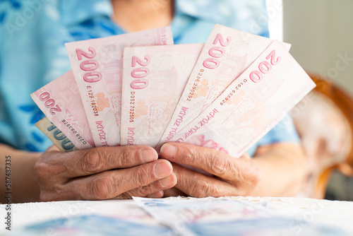 Bild auf Leinwand old women hands holding Turkish Lira banknotes