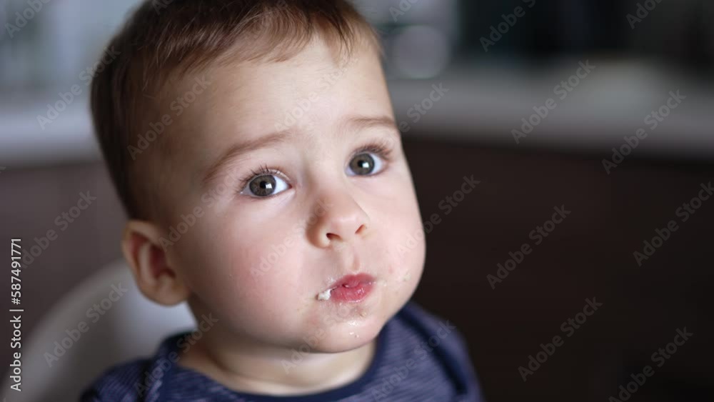 Adorable kid is fed with porridge. Portrait of a cute grey-eyed boy having meals. Close up. Adorable kid is fed with porridge. Portrait of a cute grey-eyed boy having meals. Close up.