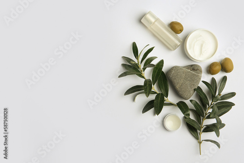 Flat lay composition with different cosmetic products and olives on white background. Space for text