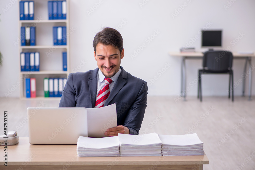 Young male employee sitting at workplace Young male employee sitting at workplace