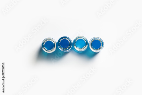 a set of flasks, jars for the laboratory with blue, blue liquid. On a white, light background. View from above.