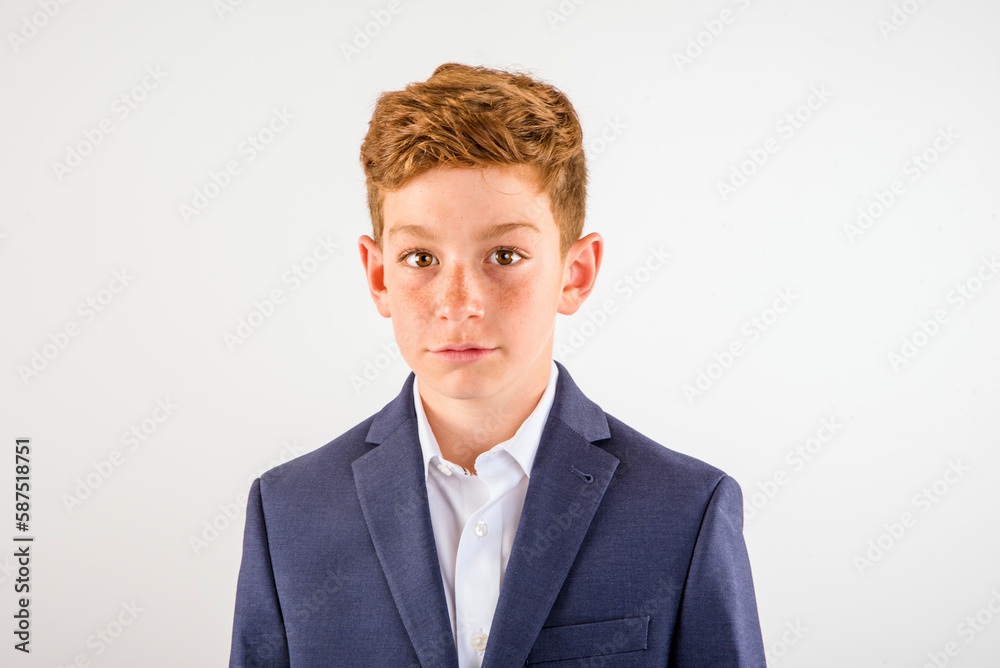 Young smiling preteen boy wearing suit standing in studio with white background Young smiling preteen boy wearing suit standing in studio with white background