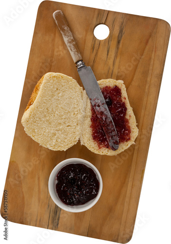 Bread with jam and knife on cutting board