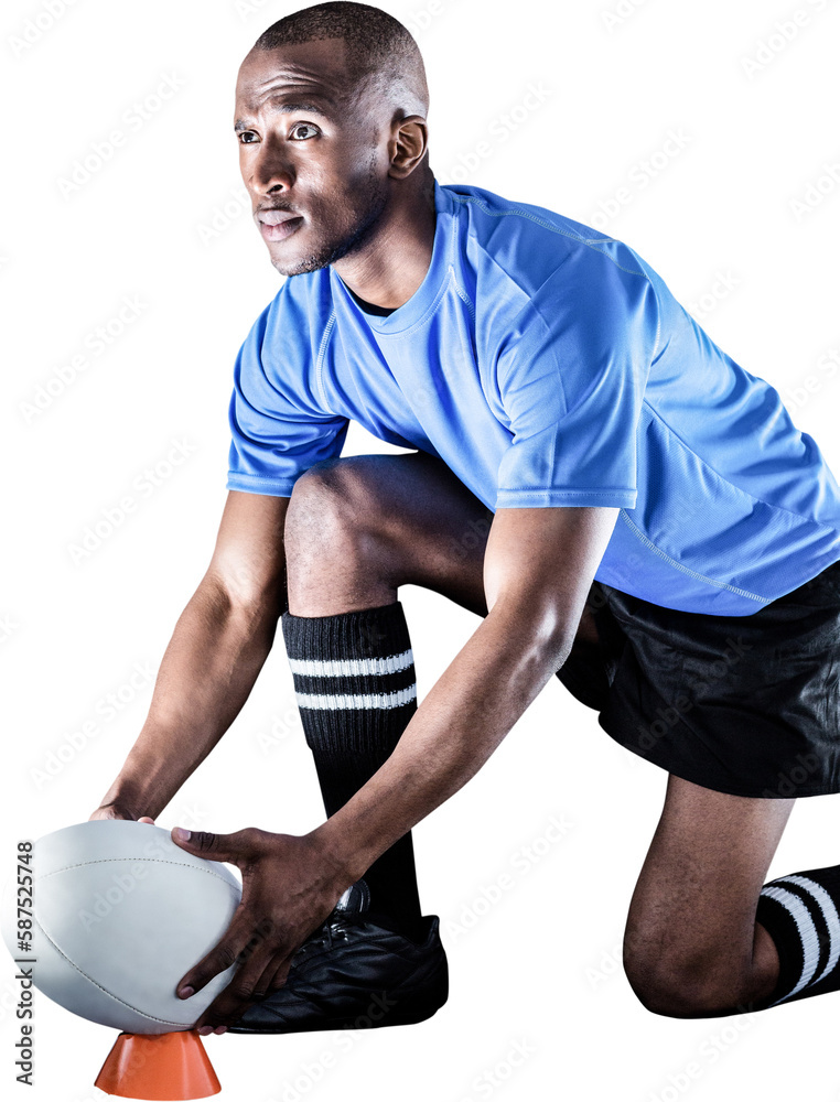 Sportsman looking away while keeping rugby ball on kicking tee