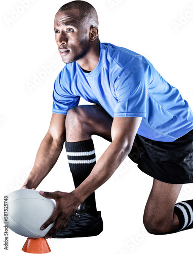 Sportsman looking away while keeping rugby ball on kicking tee