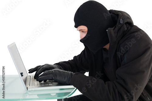 Robber sitting at desk hacking a laptop 
