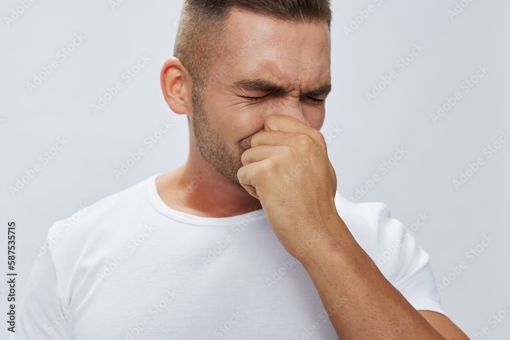 Man runny nose and cough, cold and flu, allergies, pain, in white t-shirt on white isolated background, copy space