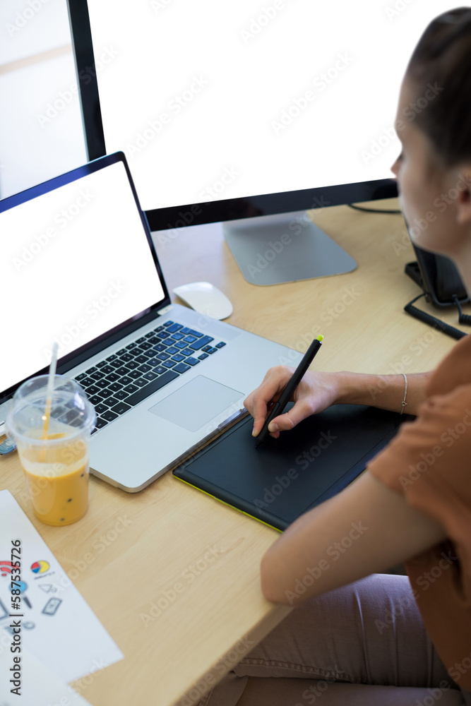 Female executive working over graphic tablet at her desk Female executive working over graphic tablet at her desk