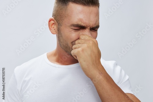 Man runny nose and cough, cold and flu, allergies, pain, in white t-shirt on white isolated background, copy space