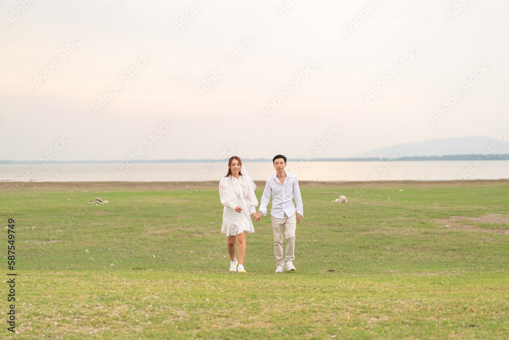 Happy young Asian couple in bride and groom clothing Happy young Asian couple in bride and groom clothing