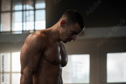 A young sexy athlete with perfect abs poses in the studio