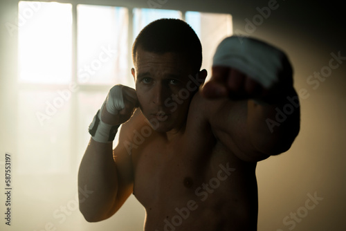 Muscular sportsman practice boxing with shadow in an abandoned warehouse. Medium shot © Videophilia