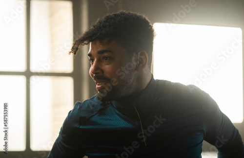 Fotografía Close-up portrait of young sportsman in sportswear standing in gym, smiling whil