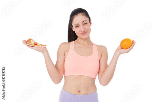 Pretty brunette holding pizza and orange