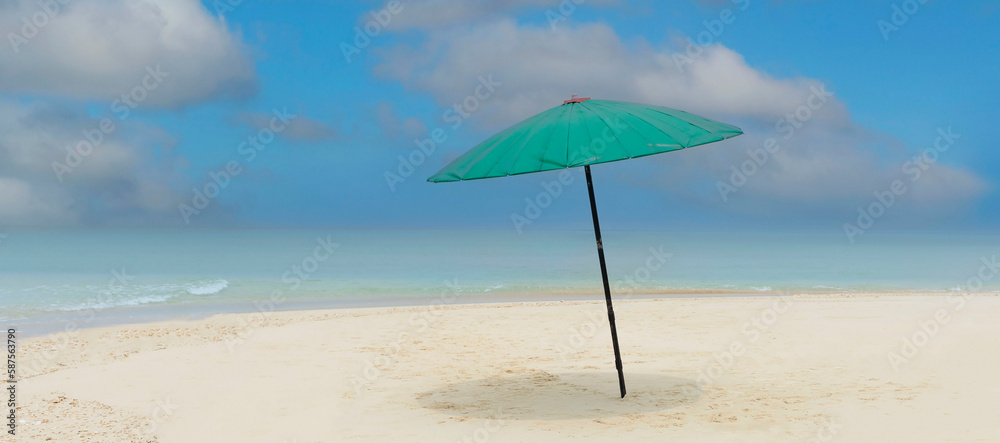 Green umbrella on the beach with summer tropical and blue sky background