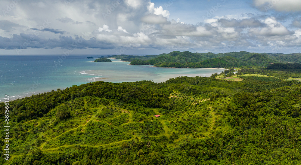 Aerial drone of coastline of Borneo island with beach and rainforest. Sabah, Malaysia.