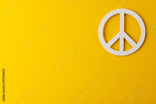 High angle view of white peace sign with copy space on yellow background