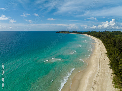Beautiful sandy beach with trees and sea surf with waves. Kalampunian Beach. Borneo, Malaysia.